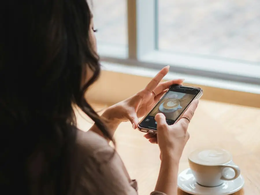 カフェでスマートフォンを見る女性